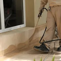 General pest control technician spraying exterior perimeter around a home in Chicago, IL